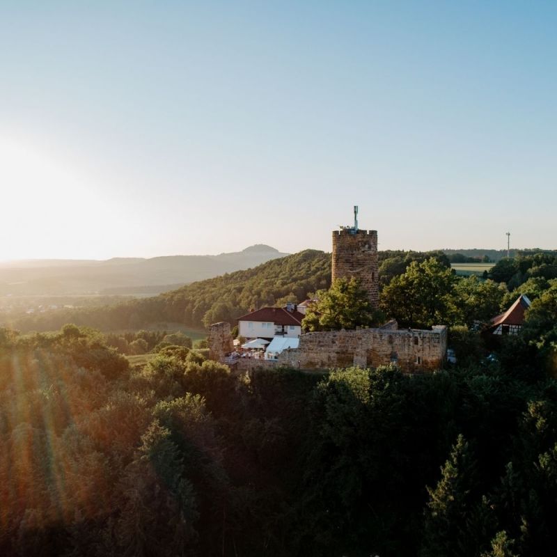 Atemberaubender Blick auf die Burganlage Drohenaufnahme bei Sonnenuntergang.